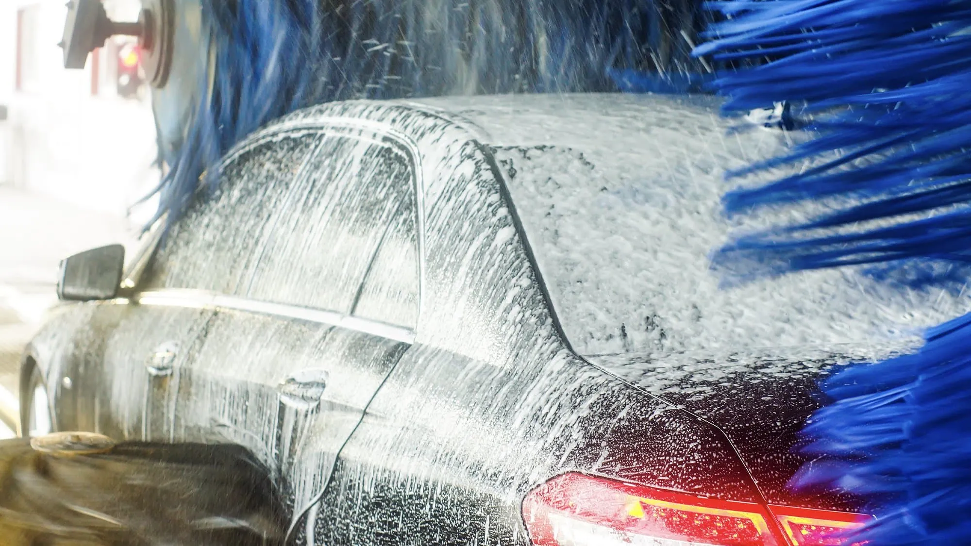 Auto onder het schuim tussen de borstels in de wasstraat van Heights Carwash